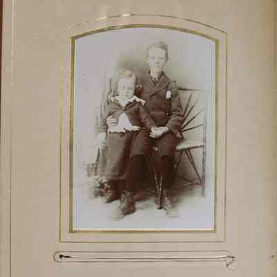 2016-024-012_img-006: Page 4 of photograph album 2016.024.012: Two young men sitting on chair.