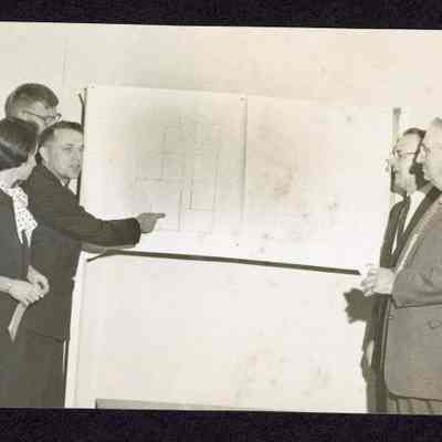 Photograph of a group of people looking at a map, unknown date and location