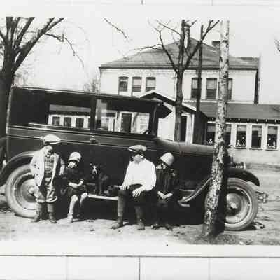 Photograph of four children on car running board