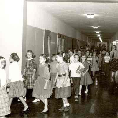Photograph of students walking inside school, circa 1960s