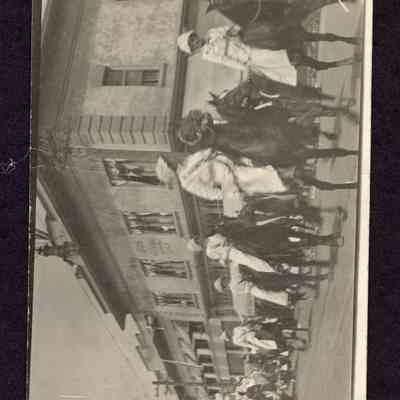 Photograph of a Post Card of a parade with a group of women on horseback. 4th and Main St. facing West, Odd Fellows building at right. Date unknown.