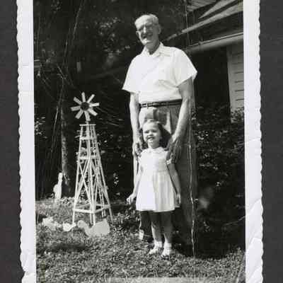 Family photograph of a young girl and a man in a yard, circa 1940