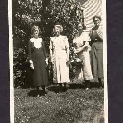 Photograph of 4 women standing outside a house