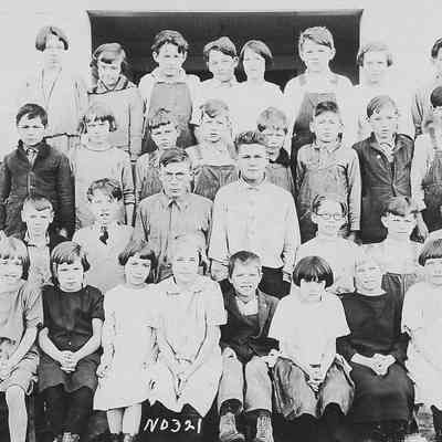 Photograph of students posed outside with female teacher, Springfield, Oregon, date unknown
