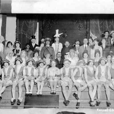Photograph of cast of local entertainment production, sitting on stage, date unknown
