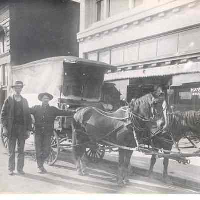 Photograph of two men with a house drawn wagon on Main Street in Springfield, Oregon