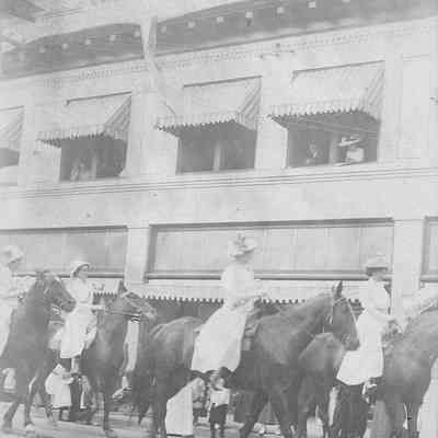 Photograph on postcard of women astride horses in parade, circa 1911