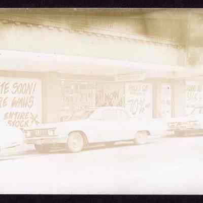 Photograph of Emporium, sales signs covering windows, undated