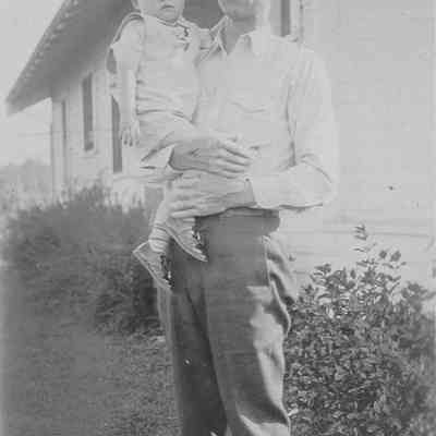 Thorval Hysten,Superintendent of Booth Kelly Lumber Co., holding son, Wyne