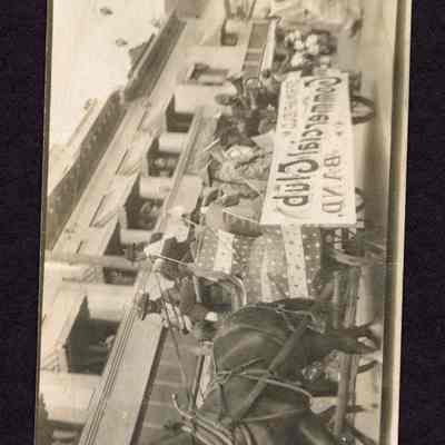 Photograph of a parade with a horse and wagon team with a band on top. Date unknown.