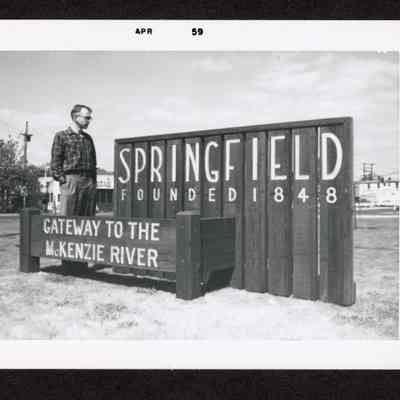 Photograph of a Springfield sign, "Springfield Founded in 1848 Gateway to the McKenzie River." April 1959.
