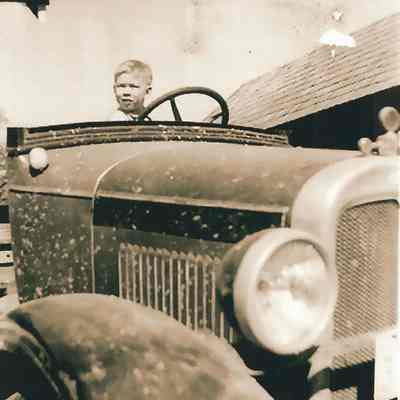 Photograph of Bob Berg in drivers seat of Old Car, Undated