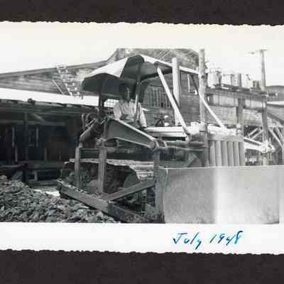 Photograph of unknown man in a caterpillar tractor at the Booth-Kelly Lumber Mill, Springfield, Oregon, 1948