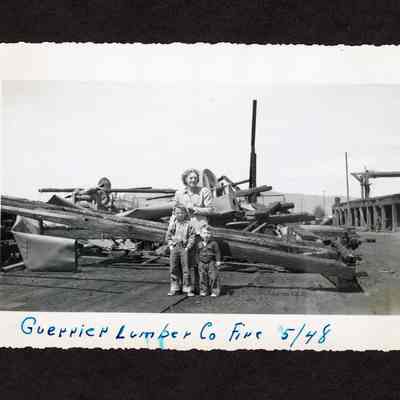 Photograph of three people infront of scrap machinery, Guerrier Fire
