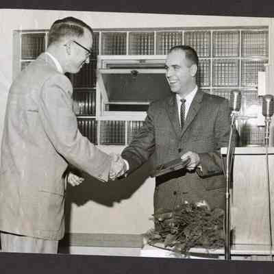 Photograph of 2 men shaking hands, Unknown date and location
