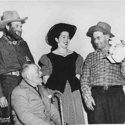 Photograph of three men and a woman in western costumes, date unknown
