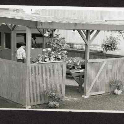 Photograph of covered area and flowers, unknown date and location