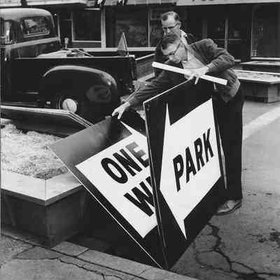 Photograph of men setting up traffic signs for Shoppers Paradise event, Springfield, Oregon, 1957