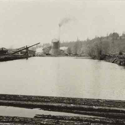 Photograph of unknown millpond and wigwam burner