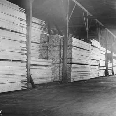 Photograph of Stacks of Lumber Inside Mill, Date Unkown