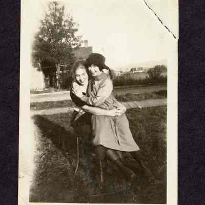 Photograph of two unknown women on a chair together outside