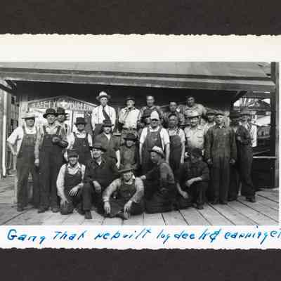 Photograph of 25 unknown men infront of safety bulletin board at Booth-Kelly Lumber Mill, Springfield, Oregon, 1948