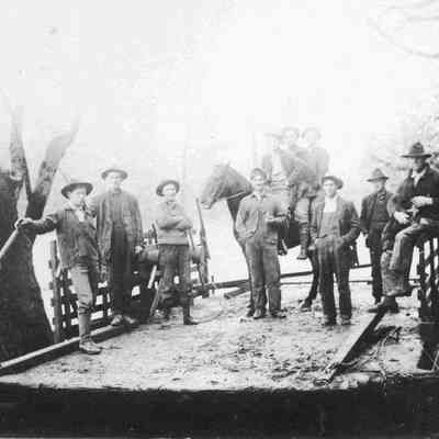 Photograph of ten unknown men and a horse on a ferry
