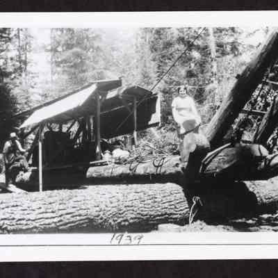 Photograph of unknown man and girl with steam donkey, 1939