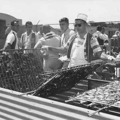 Photograph of a group of unknown men with broiler racks, 1957