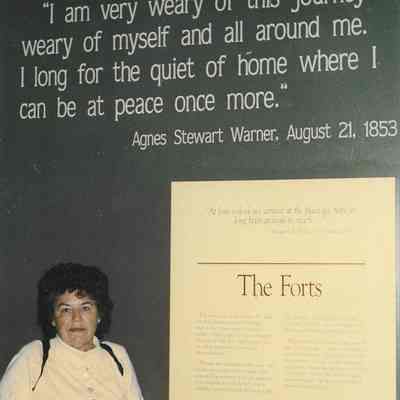 Photograph of Janice Warner Calvert, in front of a quote by Agnes Stewart Warner, circa 1990