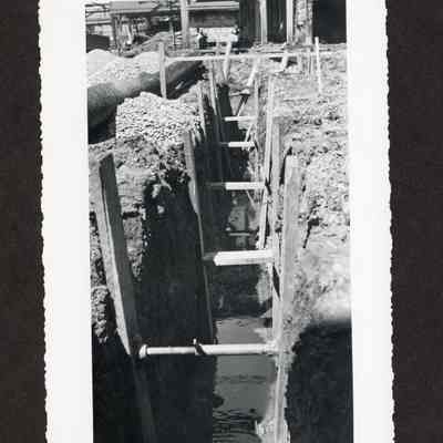 Photograph of water running through the path dug in the dirt at the Booth-Kelly Lumber Mill drainage construction site, Springfield, Oregon, 1948