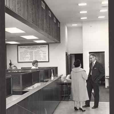 Photograph of lobby of Pacific First Federal Savings with 3 people standing. Date unknown.