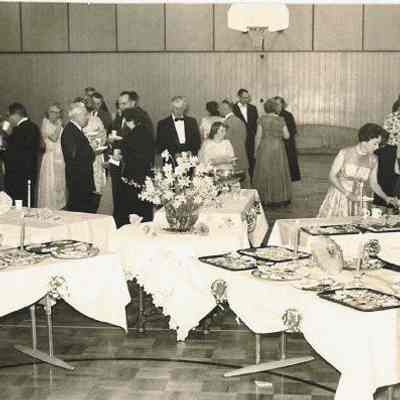 Photograph of people in formal wear at buffet tables, date unknown.