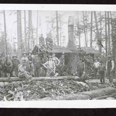 Photograph of logging crew of sixteen people at Mathias Emmerich Place
