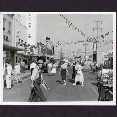 Photograph of people walking in street near McKenzie Theater, Springfield, Oregon, circa 1957
