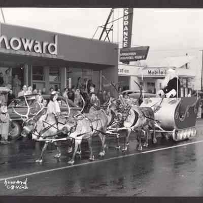Photograph of Christmas Parade. Santa in sleigh and four reindeer in front of Howard Studio. Date unknown.
