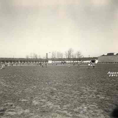 Photograph of school building with students on playground, 1954.