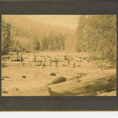 Photograph of men on logs in the Willamette River, circa 1890-1910
