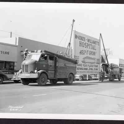 Photograph of a Moving Hospital Sign April 16, 1951. "McKenzie Willamette Hospital Help it grow!"