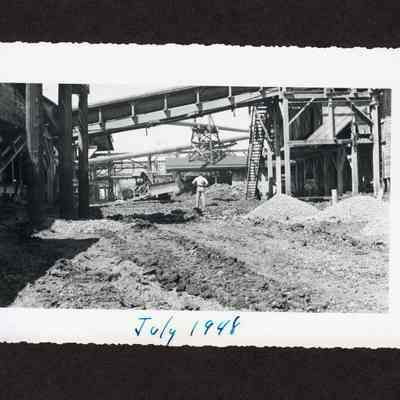 Photograph of unknown man standing in the middle of Booth-Kelly Mill drainage construction site, Springfield, Oregon, 1948