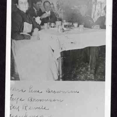 Photograph of a group of five people sitting around a table with drinks