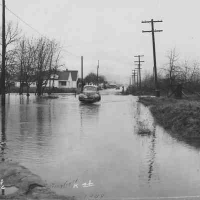Photograph of car driving through flood water, Springfield, Oregon, 1948.