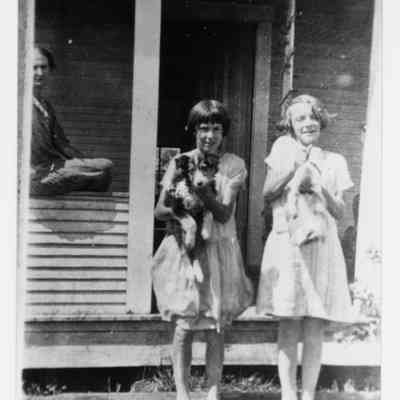 Photograph of children and a woman in front of a house, Oregon, undated