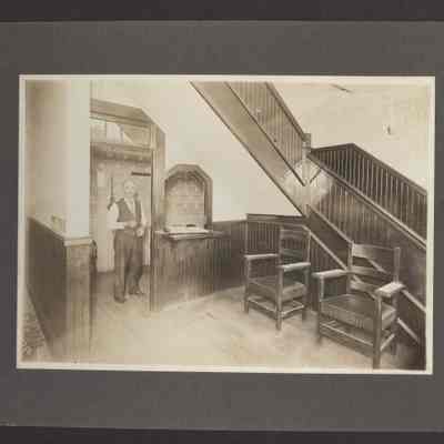 Photograph mounted on black poster board of early 1900s lobby of American Hotel L.K. Page proprietor.