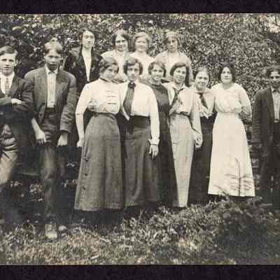 Photograph of group of thirteen people outside, circa 1910s
