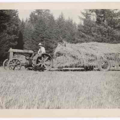 Photograph of farmer and a trailer of hay, Hidden Valley Ranch, Oregon, undated