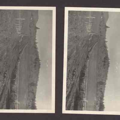 Photograph of dirt road with a house in distance and a fence on both sides. Date unknown.