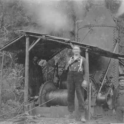 Photograph of three men and a steam engine at Landax
