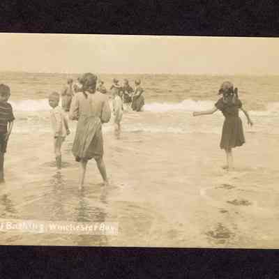 Photograph on postcard of five children and six women in the water the beach, Winchester Bay, Oregon, 1908