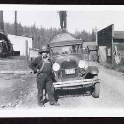 Photograph of Fred Parks standing by log truck, Mabel, Oregon, circa 1940s or 1950s